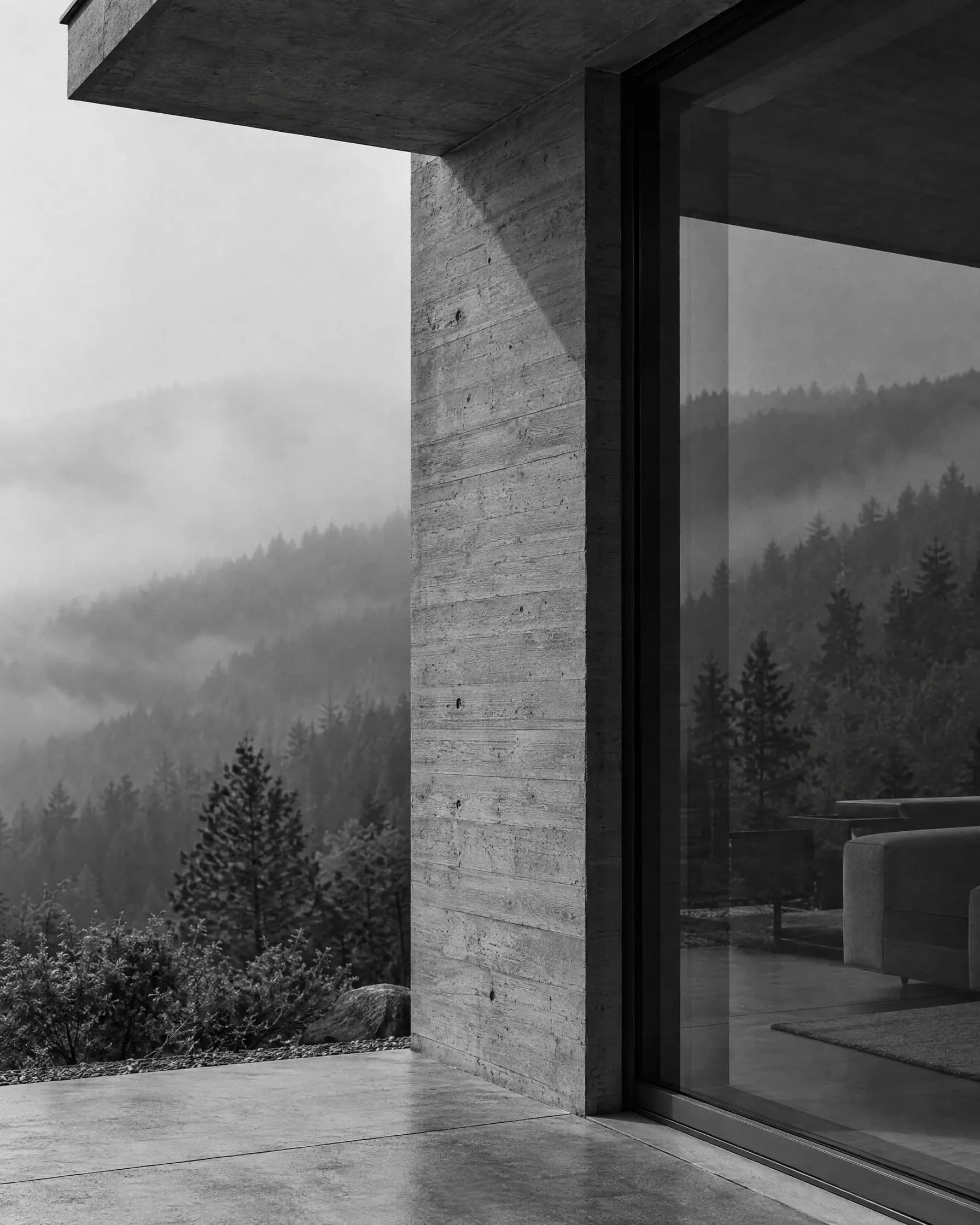 Ecke eines Hauses aus Sichtbeton mit grosser Glasfront